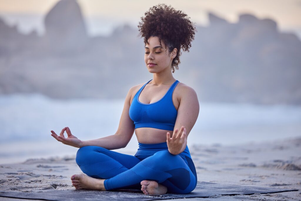 Yoga is the fountain of youth. Shot of a young female doing yoga on the beach.