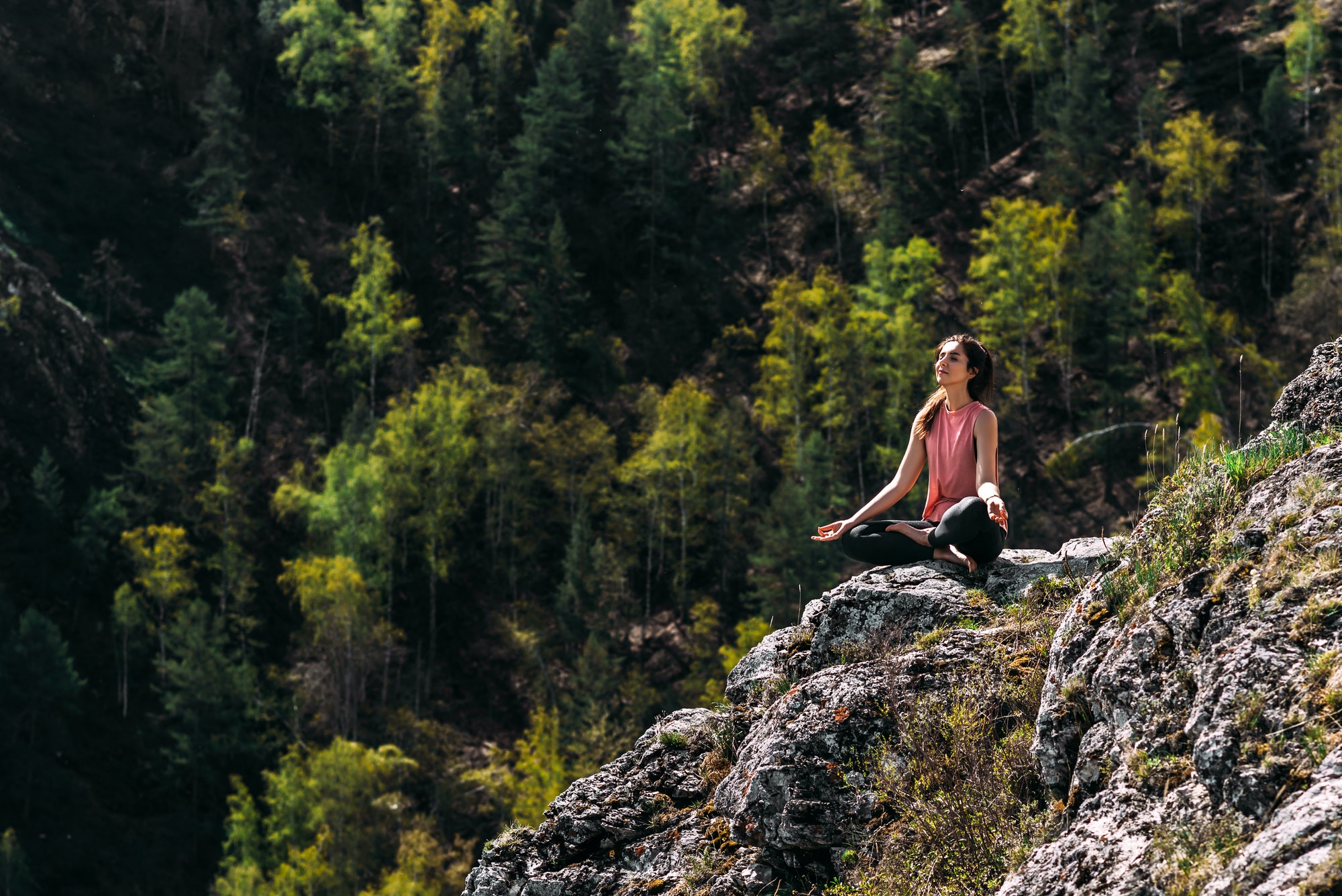 Attractive woman doing yoga. Healthy lifestyle. Woman doing yoga in the mountains.